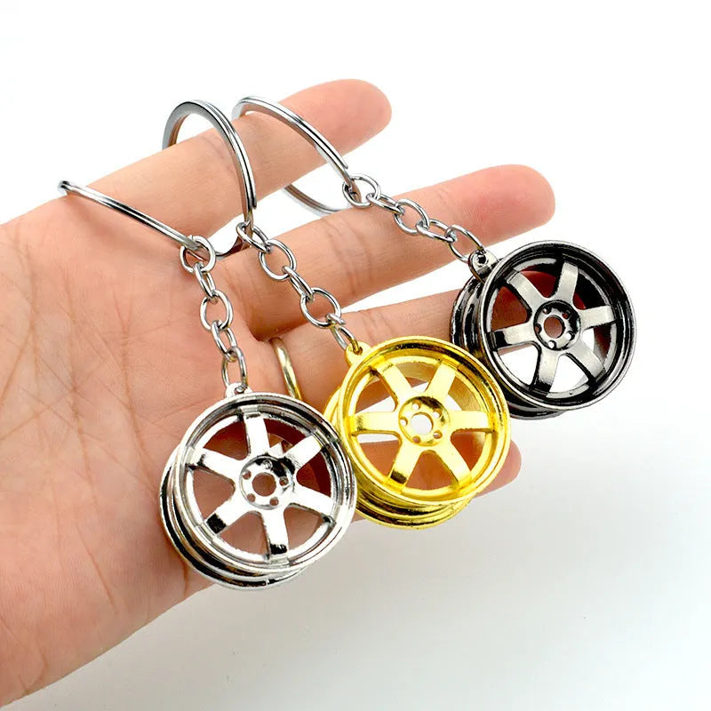 Metal keychain gifts for car enthusiasts with zinc alloy construction in three wheel hub styles including silver, gold and gun black finishes as modern simple promotional gifts suitable for Christmas, birthdays and events
