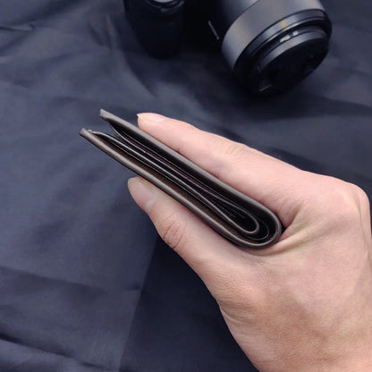 Men's brown leather wallet with a zip closure, presented in individual packaging.