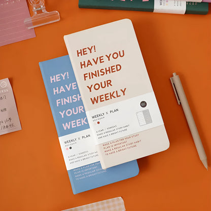 A5 weekly plan diary handbook with 100 sheets, shown in blue, brown, green, and purple colour options.