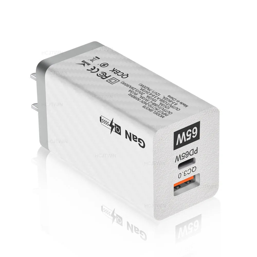 White or black GaN 65W universal laptop charger with USB-C port and compact design next to EU and US plugs