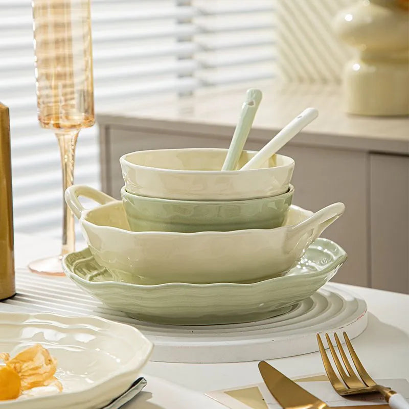 Boxed set of seven solid-colour ceramic plates and bowls on a table.