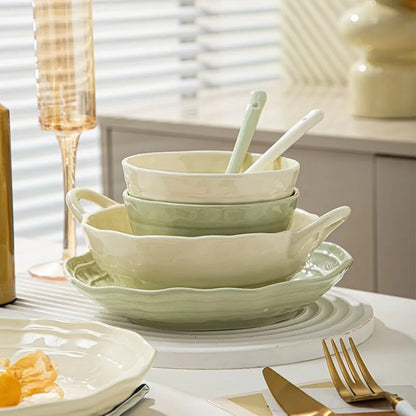 Boxed set of seven solid-colour ceramic plates and bowls on a table.