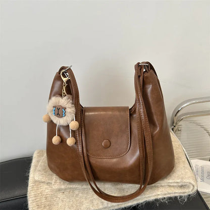 Textured PU leather women's shoulder bag in black with single strap and optional pendant