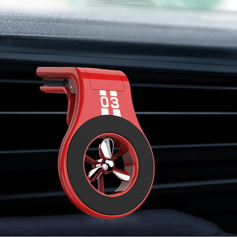 Black magnetic car phone holder attached to air vent with smartphone mounted and fragrance slices visible