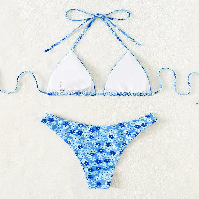 Blue printed women's bikini set with lace-up front top and high-leg split shorts on a mannequin.