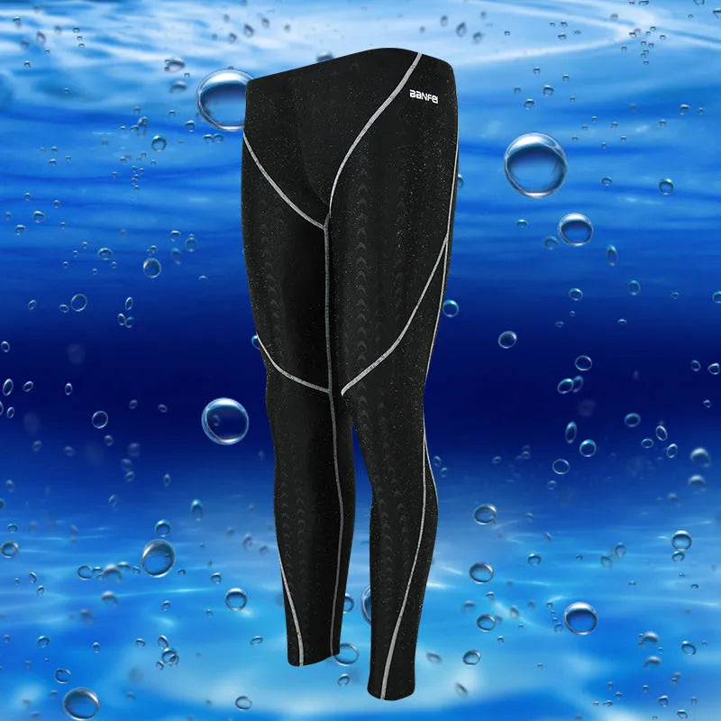 Men's black and grey cropped nylon swimming trunks with mesh lining, laid flat.
