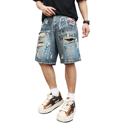 Blue denim men's shorts with ripped knees and graffiti design, featuring a straight leg and zipper fly.