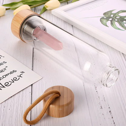 Crystal infused glass water bottle with bamboo lid showing mineral crystal inside 25cm tall container