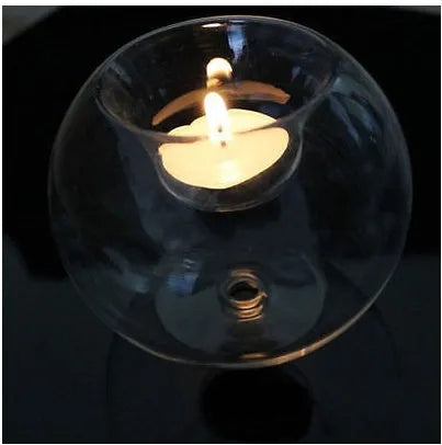 Handmade round hollow glass candle holder in three sizes on a table.