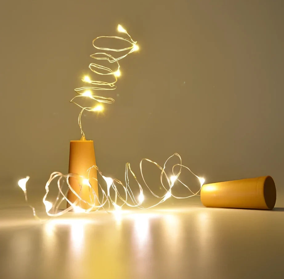 Copper wire LED string lights wrapped around wine bottle with 20 white LEDs illuminated