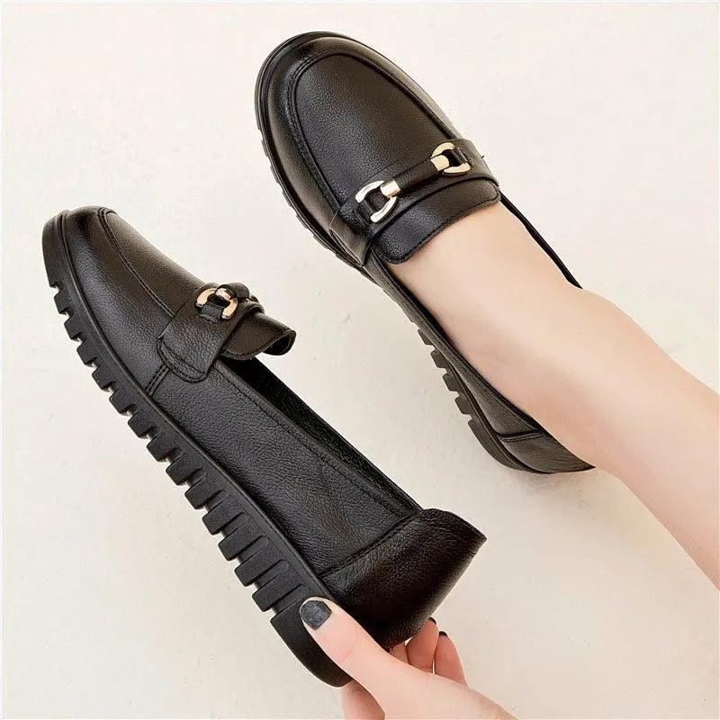 Comfortable leather pumps for middle-aged and elderly women with soft rubber soles and a low flat heel in black, featuring a round toe, shallow-cut style and a universal casual design with metal elements.