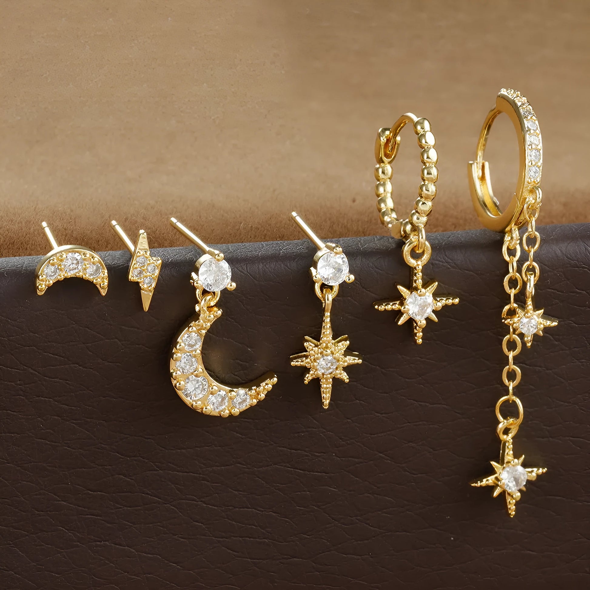 XINGX gold chain tassel earrings set showing six zircon stud earrings with dangling chain elements