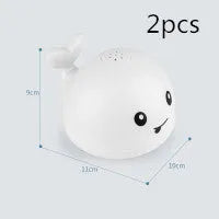 Automatic water-spraying whale bath toy with colourful lights floating in bath water.