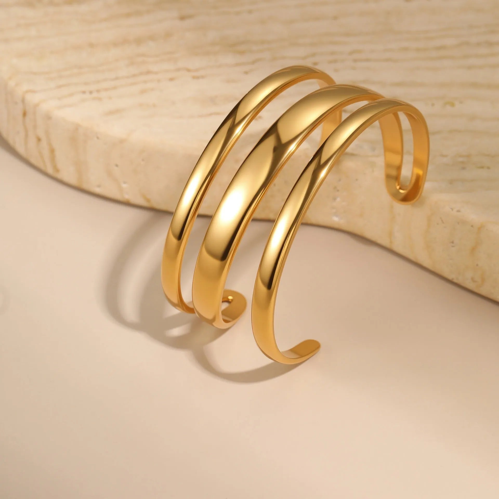 Women's stainless steel bracelet with geometric line design and simple opening clasp in gold electroplated finish