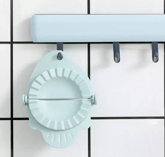 Plastic dumpling maker device in blue, green, and white for quick, uniform dumplings