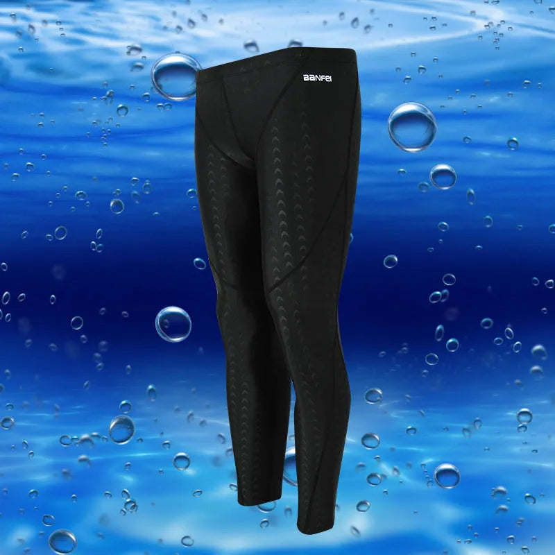 Men's black and grey cropped nylon swimming trunks with mesh lining, laid flat.