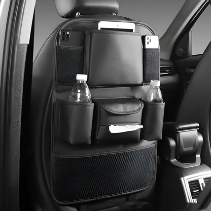 Black leather car seat back storage bag with multiple pockets, hanging behind a car headrest.