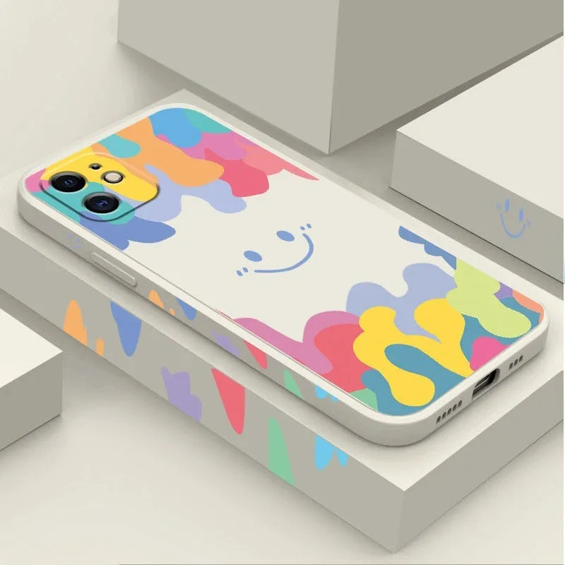 White silicone iPhone case with rainbow smiley face pattern and attached lanyard