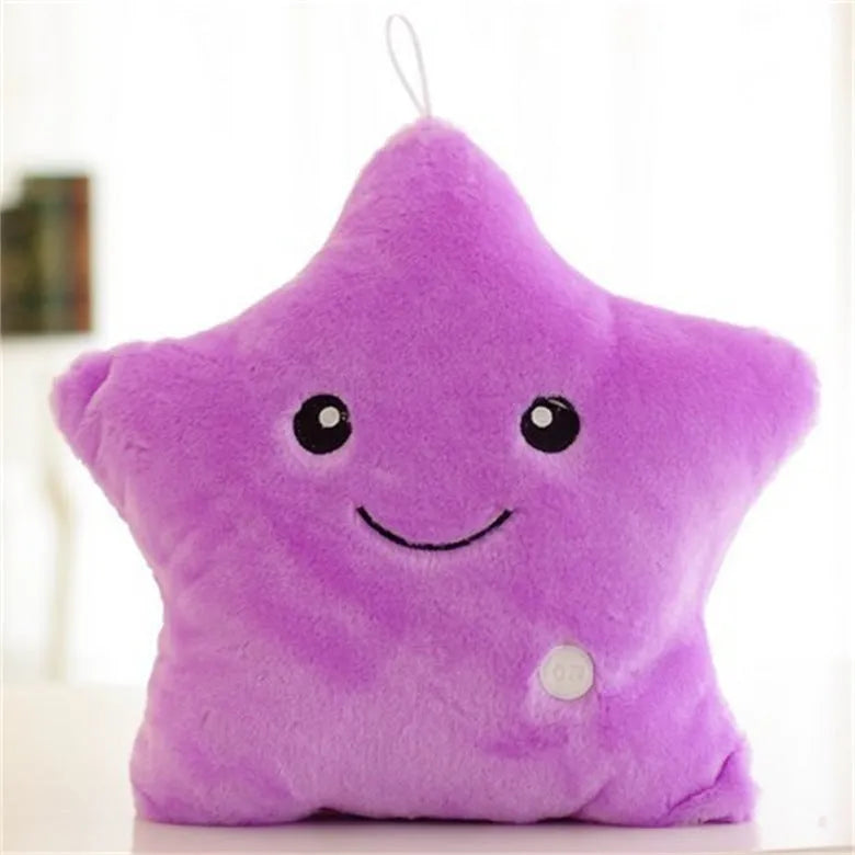 Colourful glowing five-pointed star plush pillow on a dark background.