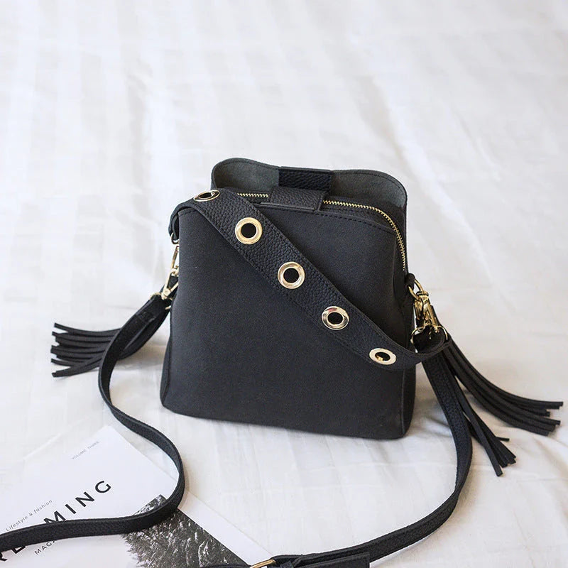 A stylish frosted tassel bucket bag with interior pockets and a versatile shoulder strap design