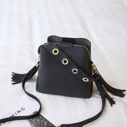 A stylish frosted tassel bucket bag with interior pockets and a versatile shoulder strap design