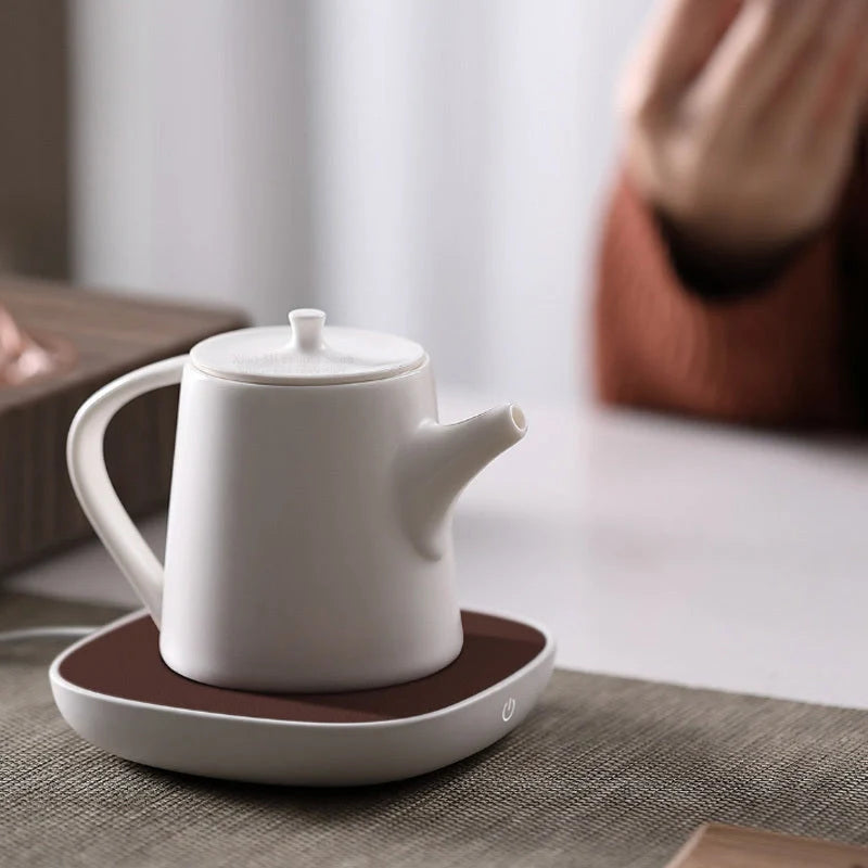 White 12V safety voltage heated base heating coaster on a wooden table