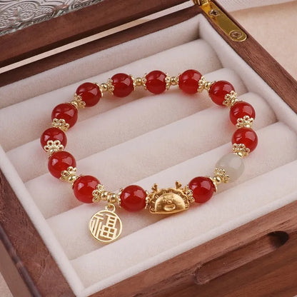 A women's glass glazed bracelet with floral and zodiac animal charms in red, pink, and white pearl beads.
