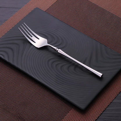 Four-piece stainless steel cutlery set showing main knife, fork, spoon, and teaspoon with mirror finish