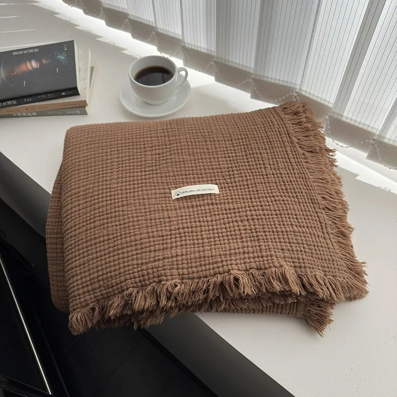 Four-layer gauze tassel blanket in cotton, showing tassel edges and textured fabric, available in multiple colours and sizes