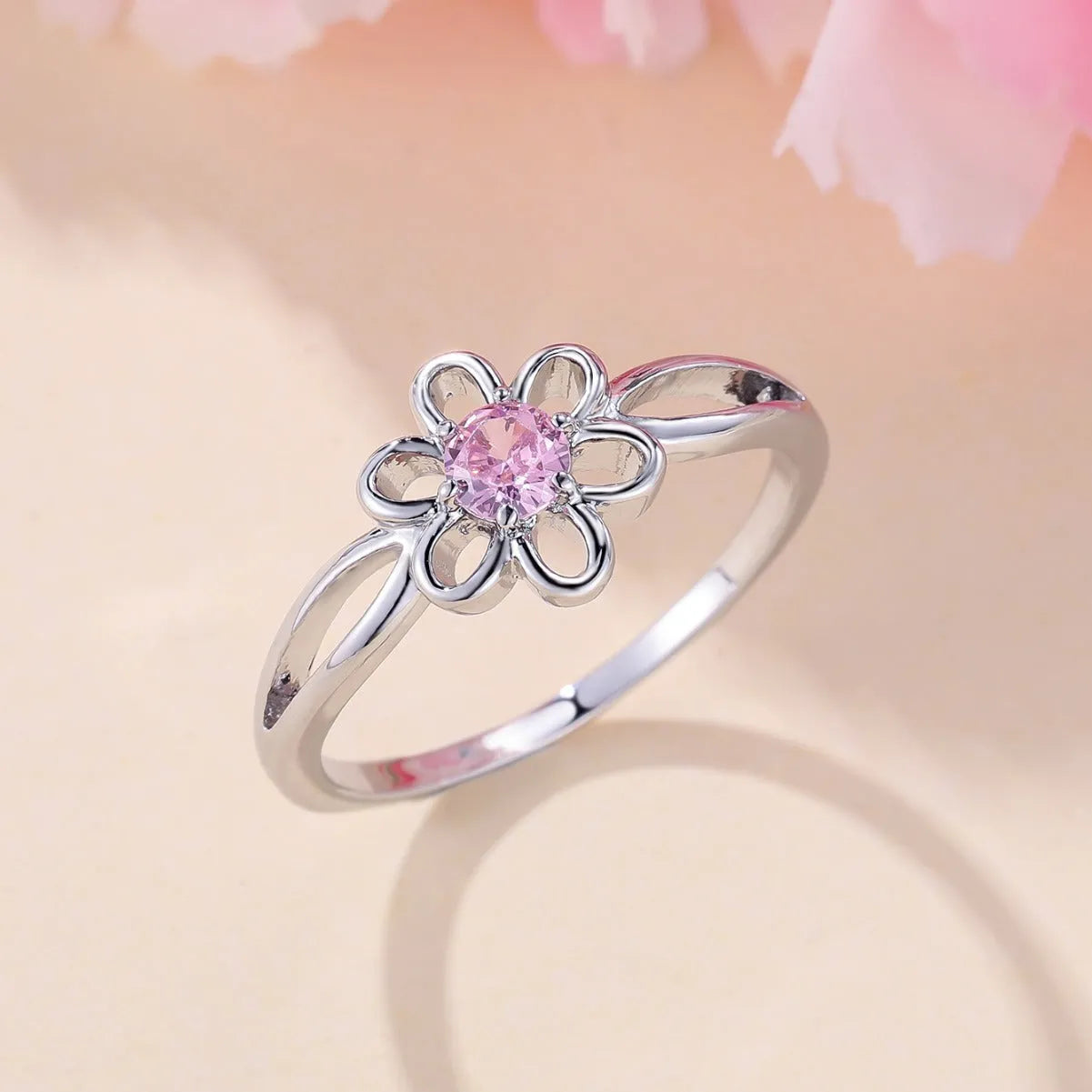 Women's hollow flower design fashion ring in electroplated copper with a platinum pink diamond finish.