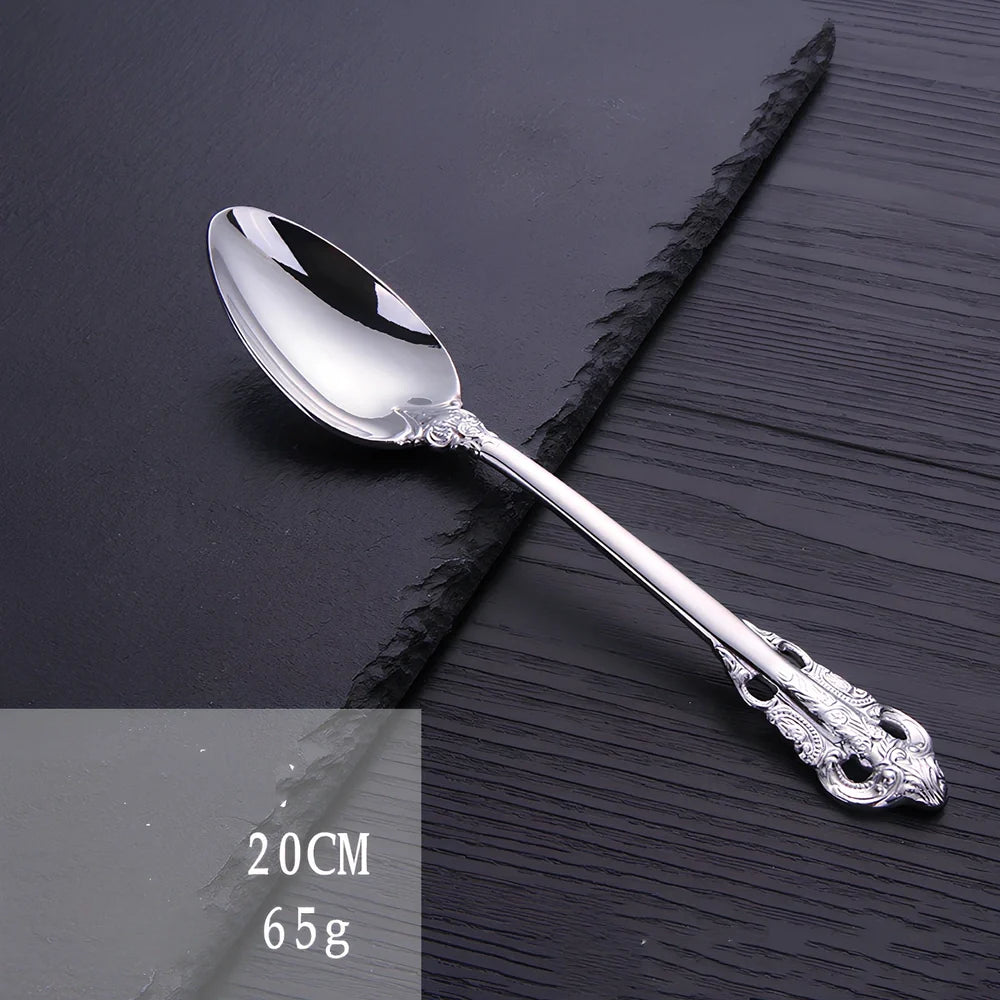 Four-piece stainless steel cutlery set showing main knife, fork, spoon, and teaspoon with mirror finish