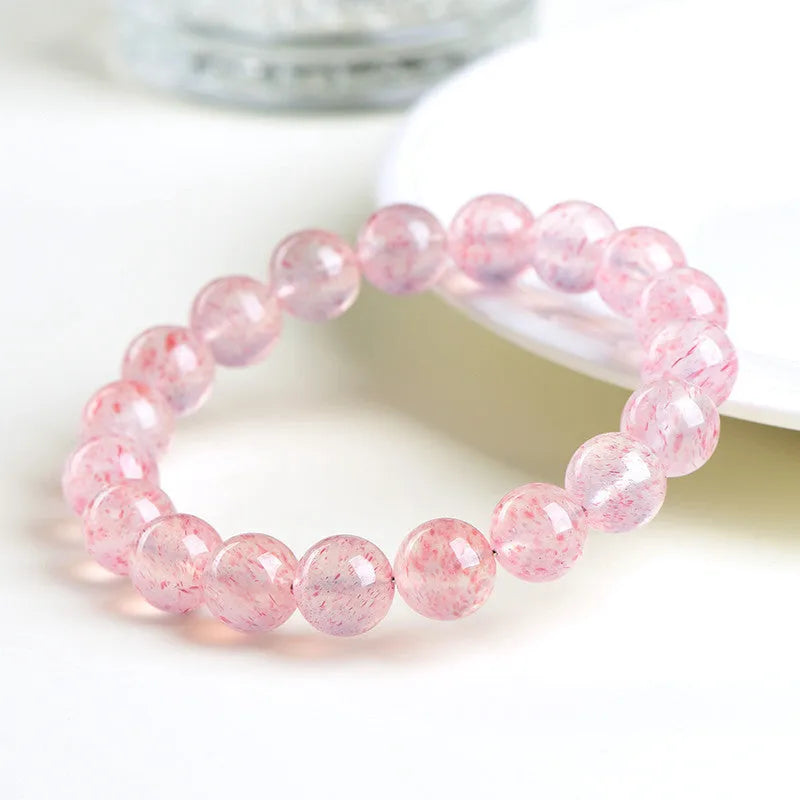 Stretch bracelet with round faceted strawberry quartz crystal beads in a white water colour.