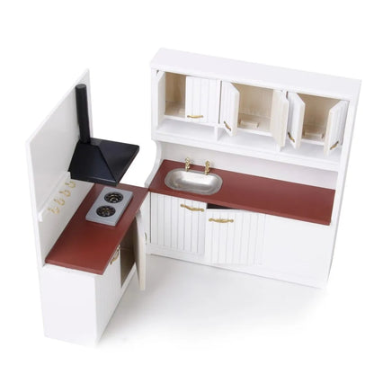 White two-piece dollhouse kitchen cabinet set with sink and stove units on a table.