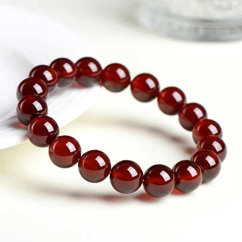 Natural orange red garnet crystal ball bracelet with traditional Ruyi design elements and adjustable bead sizing