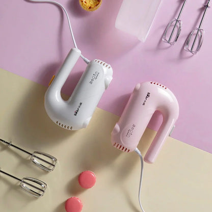 Pink electric hand whisk with stainless steel attachments for whipping eggs and cream