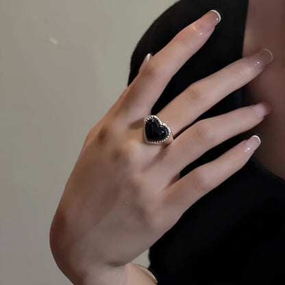 S925 sterling silver ring with a polished black heart-shaped agate stone on an adjustable open band.