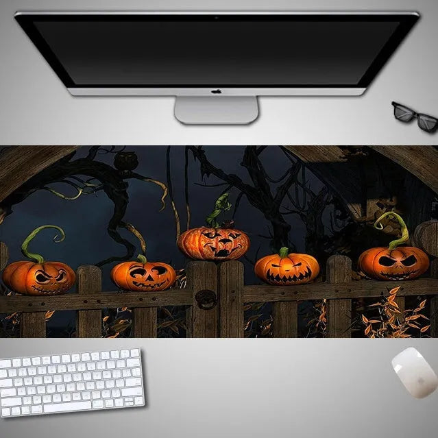 Halloween-themed oversized cloth mouse pad with non-slip rubber base on a wooden desk.