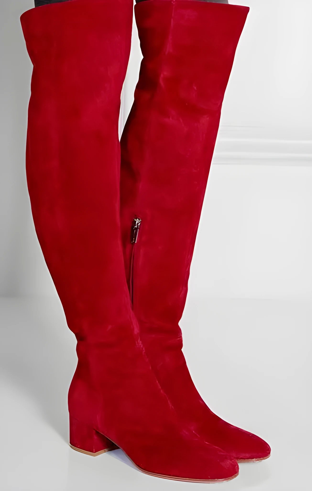 Women's grey suede over-the-knee flat boots with pointed toe and thick rubber sole on a neutral background