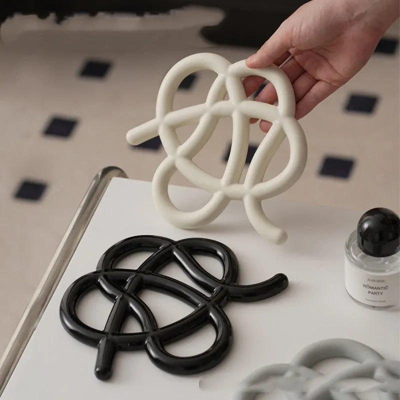 Ceramic heat-proof mat in irregular shape on dining table, protecting surface from hot pot