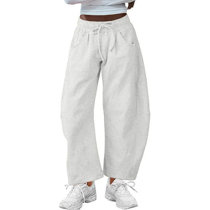 Loose fit cropped sweatpants in apricot colour with drawstring waist and side pockets on a neutral background.