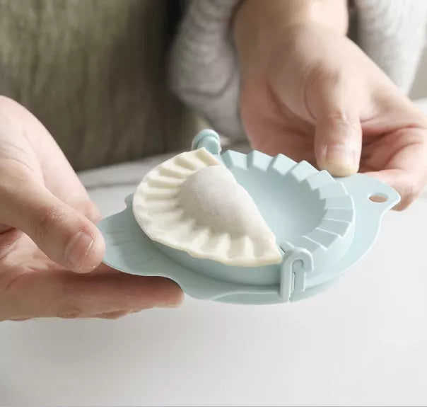 Plastic dumpling maker device in blue, green, and white for quick, uniform dumplings