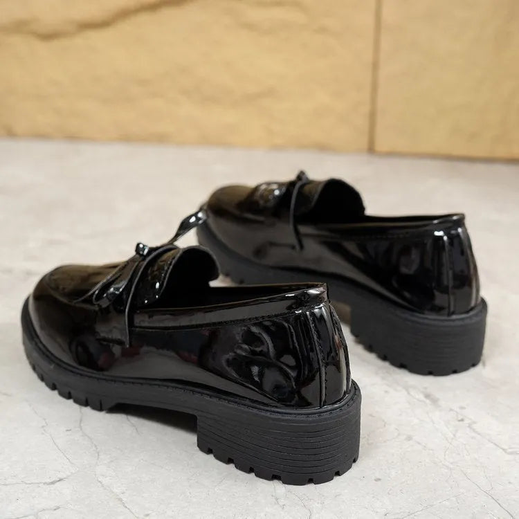 Women's black slip-on loafer shoe with a decorative bow on the front.