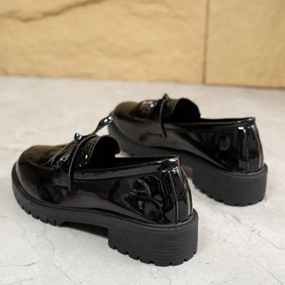Women's black slip-on loafer shoe with a decorative bow on the front.
