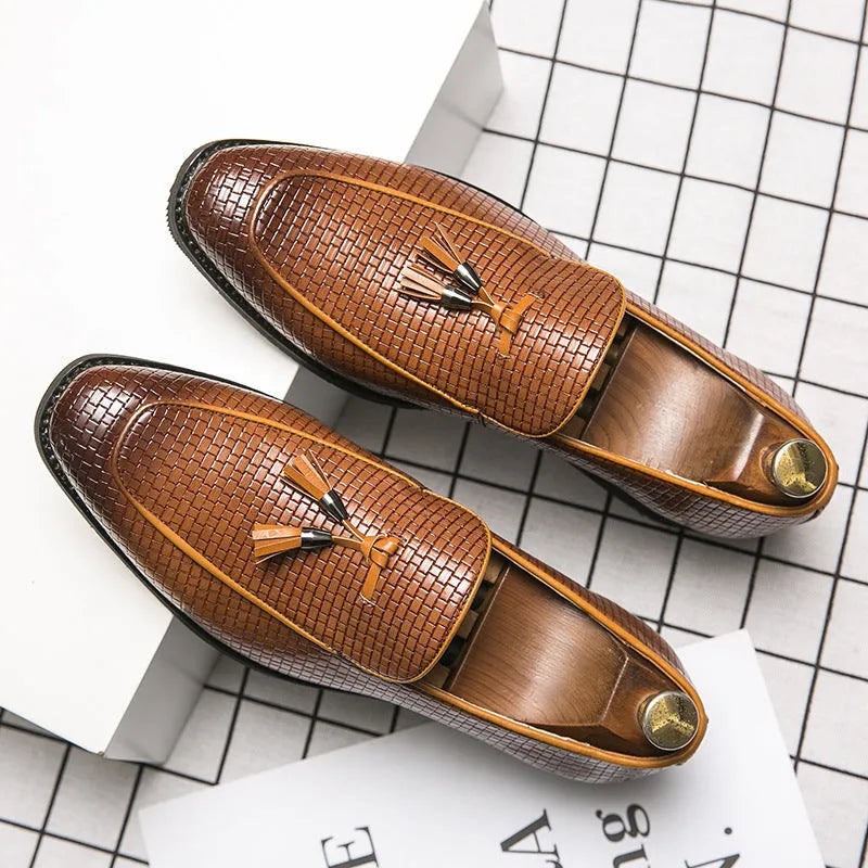 Men's black pointed toe slip on shoe with a decorative tassel on the artificial PU upper.