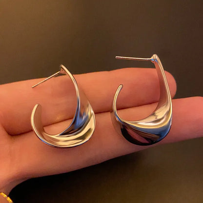 Gold twisted geometric metal earrings with circular elements and electroplated finish
