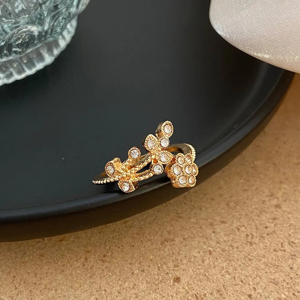Women's copper open ring with diamond-treated flower and leaf design in gold colour.
