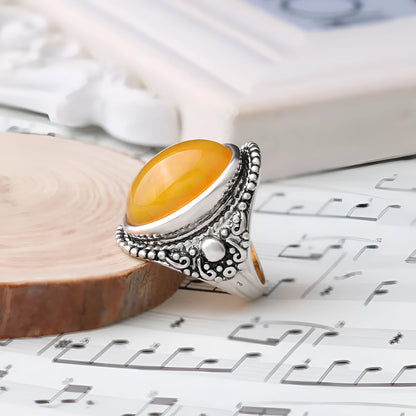 Geometric antique silver amber alloy ring with fluorescent beeswax plating on a model's finger.