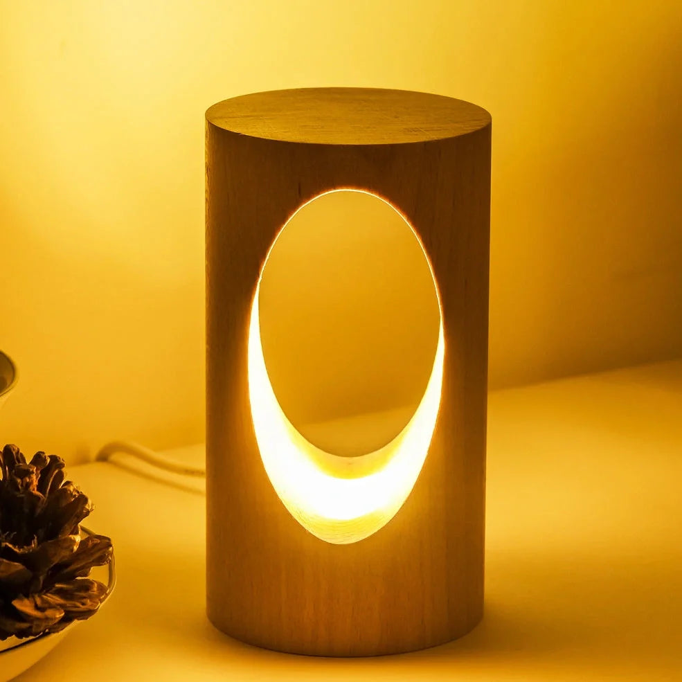 Solid wood LED reading lamp with adjustable arm and glass holder on wooden surface