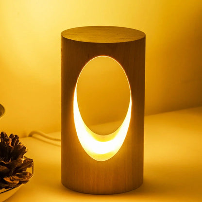 Solid wood LED reading lamp with adjustable arm and glass holder on wooden surface