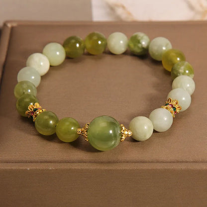Original design women's bracelet with a green Xiuyan jade stone on wrist.
